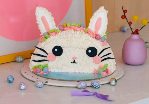 buttercream piped easter bunny cake with super cute fondant face, whiskers and candy easter eggs