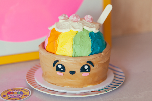 Very cute cake made to resemble a Hawaiian Shave Ice frozen dessert, with rainbow buttercream and kawaii style face, plus real mochi.