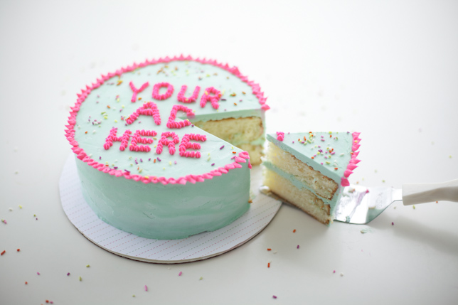 side view of green cake with pink piped letters