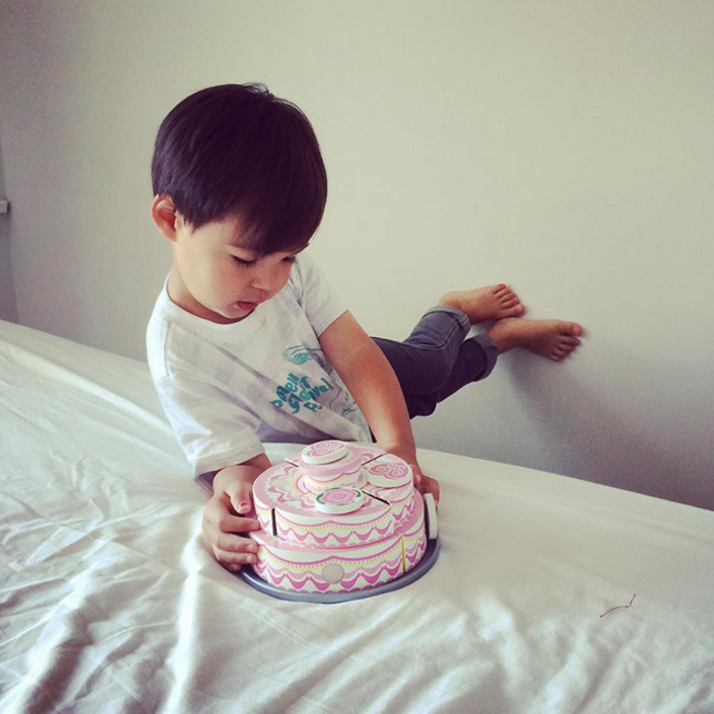 little boy with wooden cake toy
